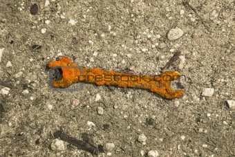 Old rusty wrench on ground