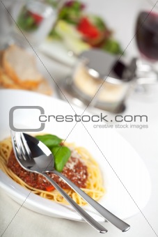 plate with spaghetti bolognese and basil leaf