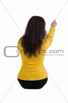 Young woman points at wall.
