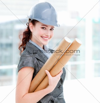 Portrait of a smiling female architect holding blueprints