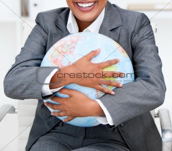 Close-up of a smiling businesswoman holding a terrestrial globe