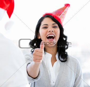 Positive businesswoman doing a thumb-up to celebrate christmas