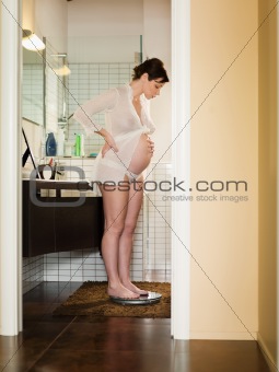 pregnant woman measuring weight;