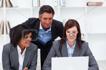 Charming businesswomen and their colleague working at a laptop