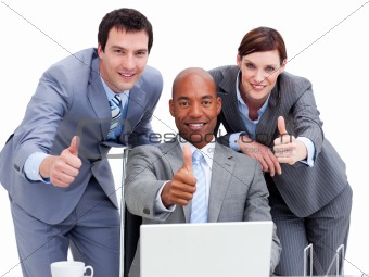 Business people with thumbs up looking at a laptop
