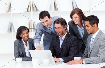 Multi-cultural business team looking at a laptop