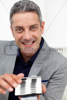 Smiling businessman holding a business card holder 