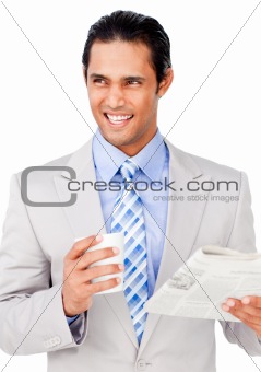 Confident businessman driking coffee while reading a newspaper