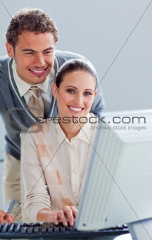 Attentive businessman helping his colleague work at a computer