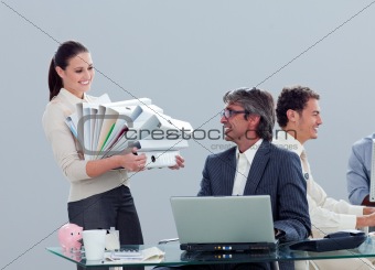 Pretty businesswoman carrying a stack of folders with her collea