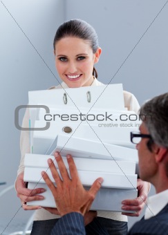 Young businesswoman and her manager carrying a pile of folders