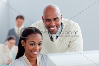 Portrait of two  attractive businesspeople working at a computer