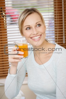 young woman holding orange-carrot juice