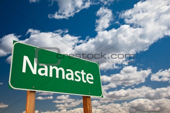 Namaste Green Road Sign with Copy Room Over The Dramatic Clouds and Sky.