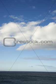 Blue sky and clouds over ocean.