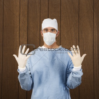 Male surgeon wearing mask and gloves.