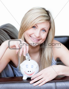 Delighted woman using a piggybank 