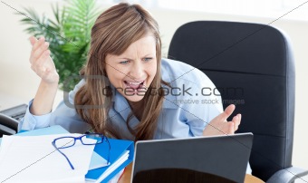Astonished businesswoman looking at the laptop 