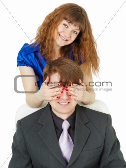 Playful woman covered eyes of man