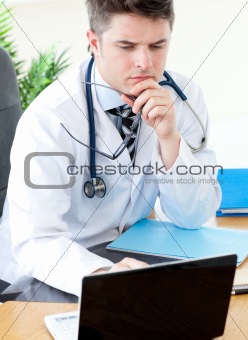 Worried male doctor using a laptop 