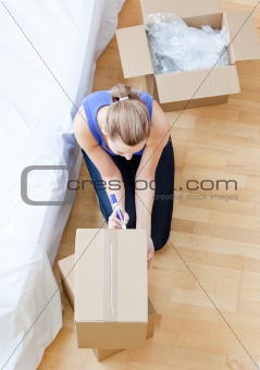 Beautiful woman writing on a box