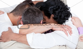 Confident business team hugging each other in a circle 