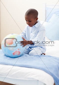 Little boy holding a terrestrial globe