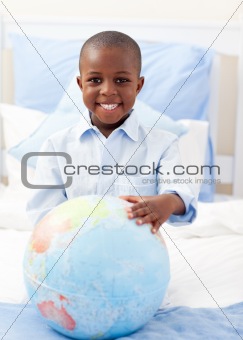 Cute little boy holding a terrestrial globe