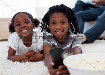 Afro american children watching television and eating pop corn