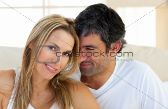 Portrait of a loving couple sitting on bed at home