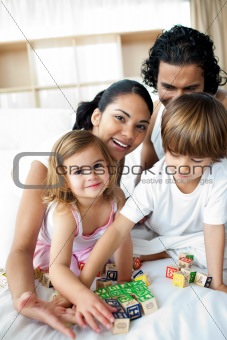 Portrait of a happy family playing with letter blocks 