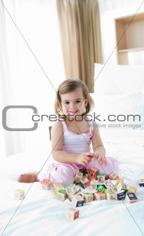 Cute little girl playing with alphabetics blocks