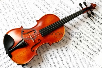 contrast brown violin with sheets of papper as fon