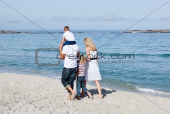 Affectionate family walking on the sand 