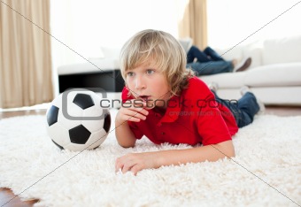 Animated boy watching football match lying on the floor 