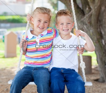 Cute siblings swinging 
