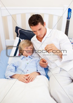 Attractive father checking his son's temperature