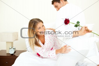 Attentive man giving a rose to his wife 
