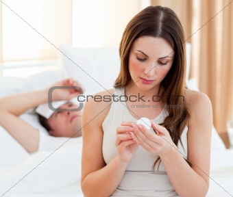 Attentive woman giving medicine to her sick husband