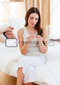Attentive woman taking her sick husband's temperature 