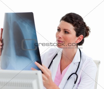 Pensive female doctor looking at X-ray in his office