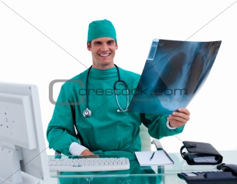 Young surgeon looking at X-ray
