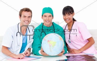 Joyful medical team looking at terrestrial globe