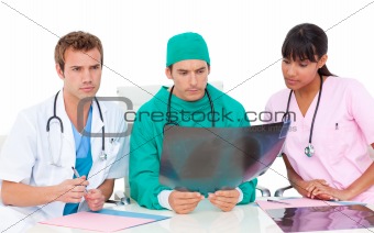 Serious medical team looking at X-ray