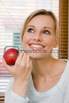 Beautiful Relaxed Woman Holding an Apple Beside Her Face