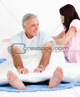 Attentive nurse fixing her patient's bed 