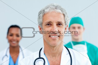 Close up of a senior Doctor standing in front of his team