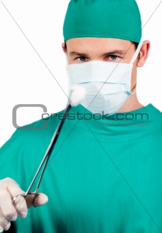 Self-assured male surgeon holding surgical forceps