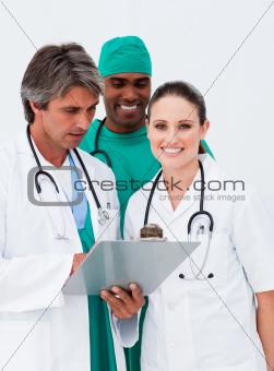 Smiling female doctor taking notes with her colleagues