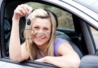 Portrait of an enthusiastic young driver holding a key after buying a new car